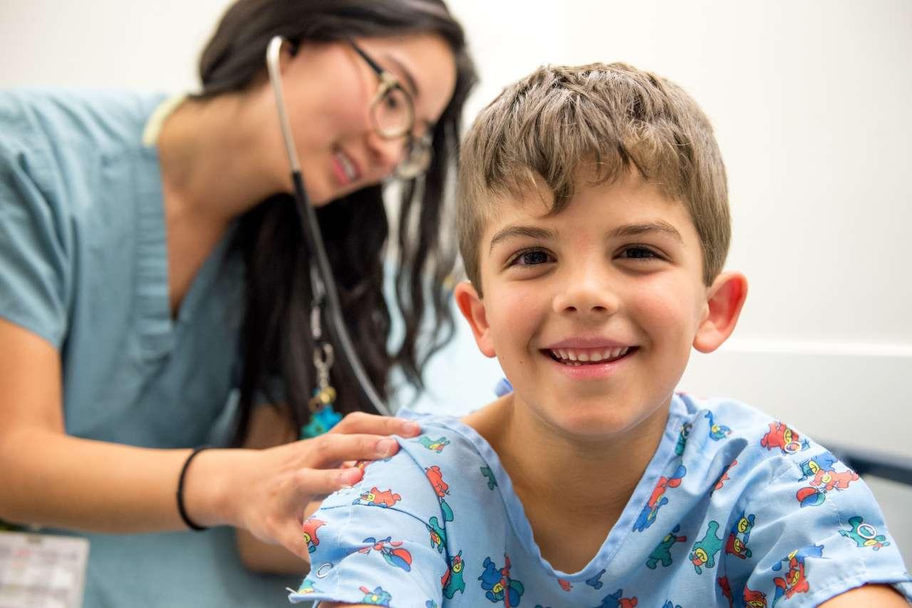 Boy smiling while nurse checks heartbeat